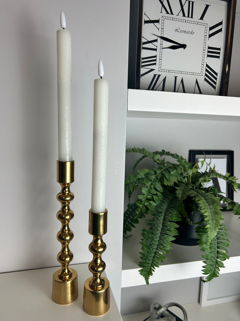 Round glass candle holder filled with dried flowers